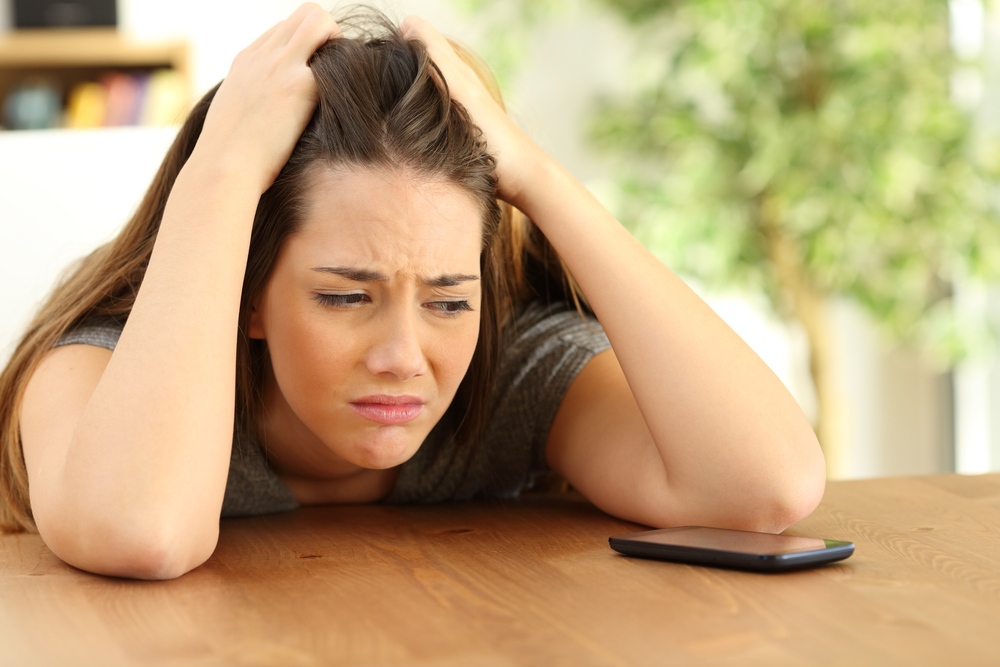 Woman feeling sad looking at phone