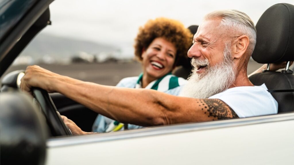 Middle aged couple driving in convertible car